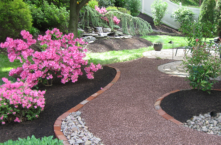 winding and shaded garden path around flowerbeds